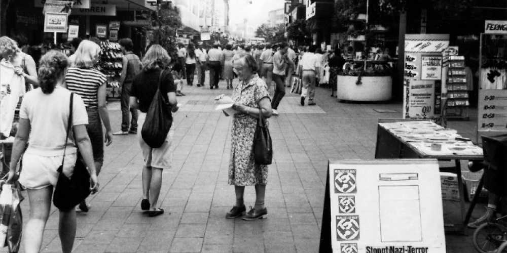 Marie Luise Hartmann verteilt Flyer bei einem Infostand 1982 in Bielefeld.