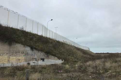 Stacheldrahtzäune entlang des Autobahnzubringers zum Fährhafen von Calais.