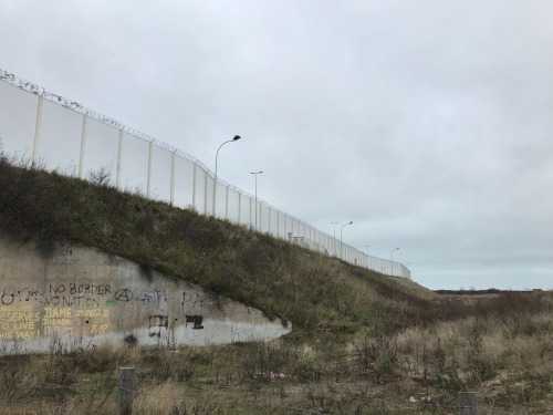 Stacheldrahtzäune entlang des Autobahnzubringers zum Fährhafen von Calais.